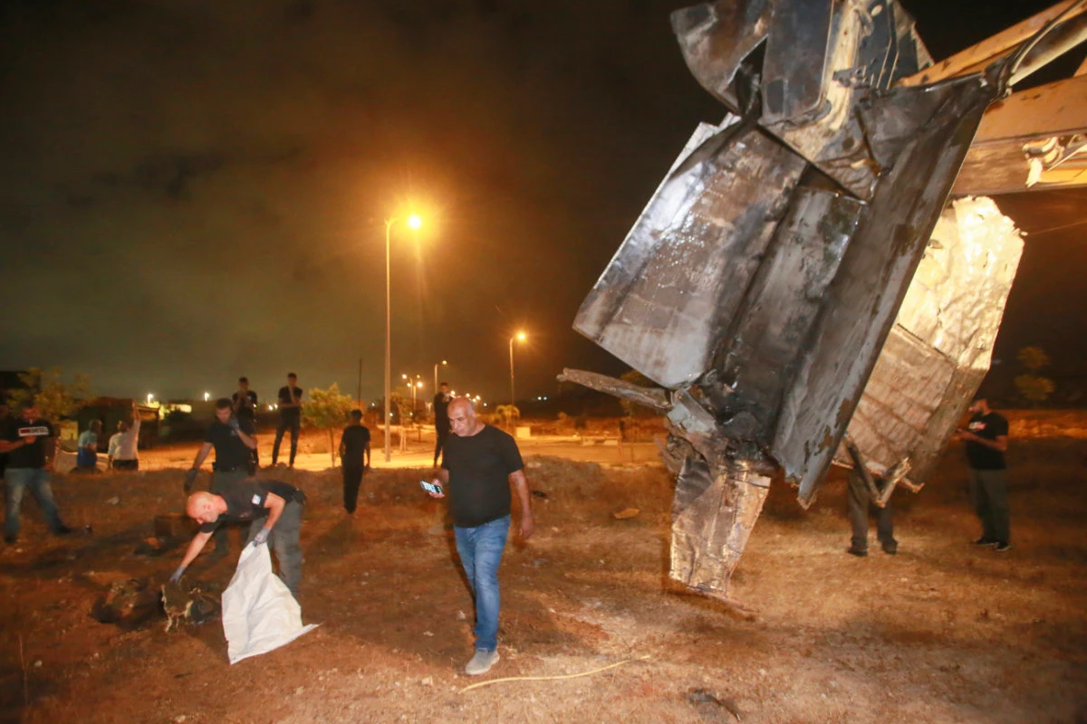 Israeli authorities inspect the remains of what the military said is a Syrian anti-aircraft rocket that exploded in the air, in the town of Rahat, Israel, on July 2, 2023. (AP Photo)