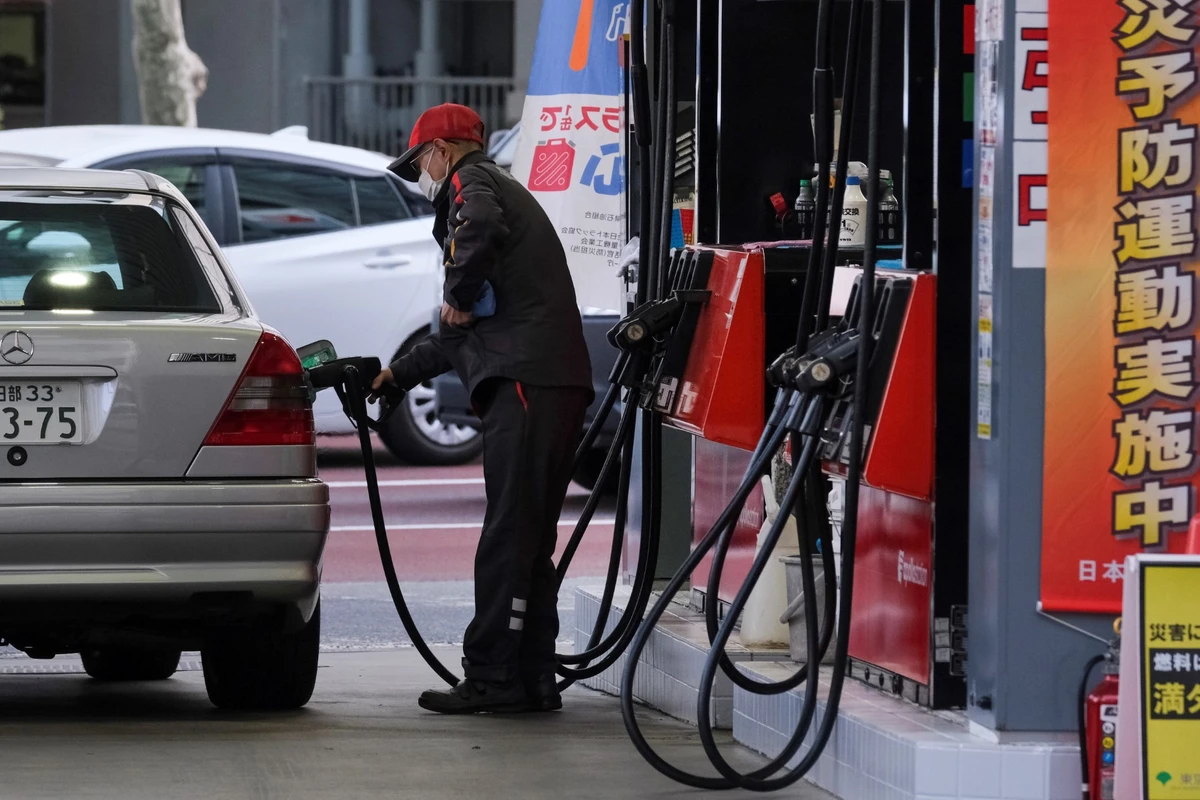 A service station attendant fills up a vehicle at a petrol station in Tokyo (AFP)