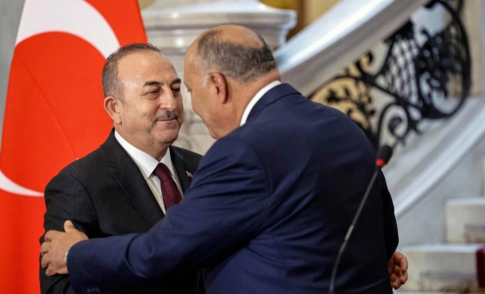 Egypt’s Foreign Minister Sameh Shoukry, right, greets his Turkish counterpart Mevlut Cavusoglu in Cairo on March 18, 2023. (AFP)