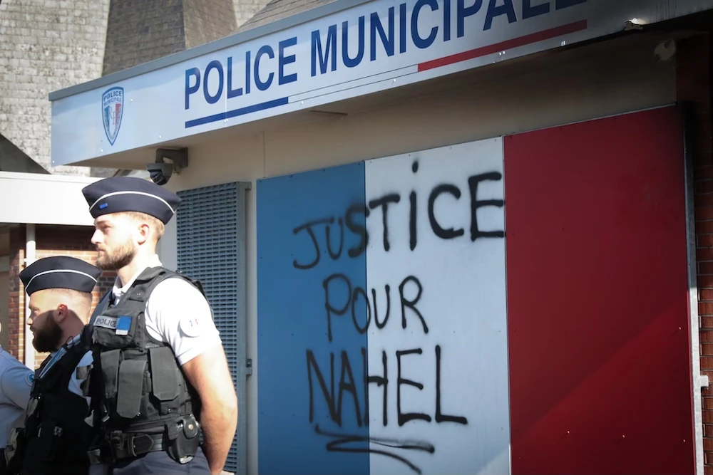 Police officers stand outside a police station bearing the inscription “Justice for Nahel,” in the city of Lisieux, France, on July 6, 2023. (AFP)