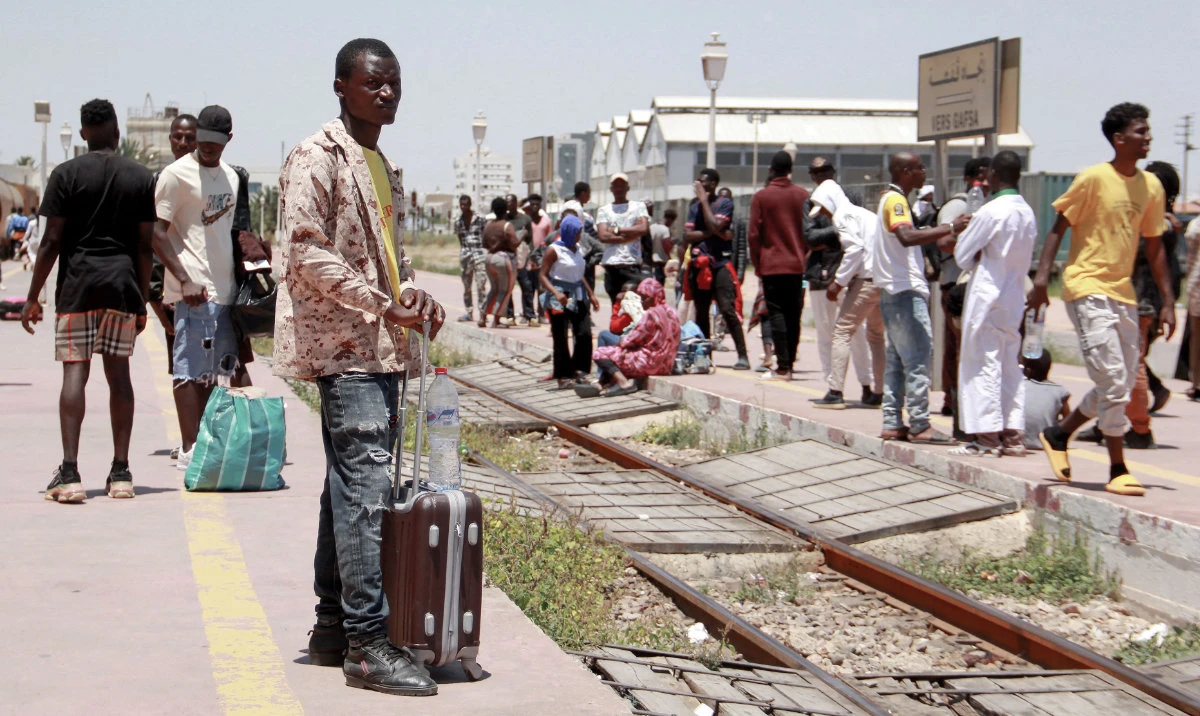 African migrants wait for a train as they flee to Tunis amid unrest in the coastal city of Sfax. Racial tension in Sfax has flared into violence targeting migrants. (File/AFP)