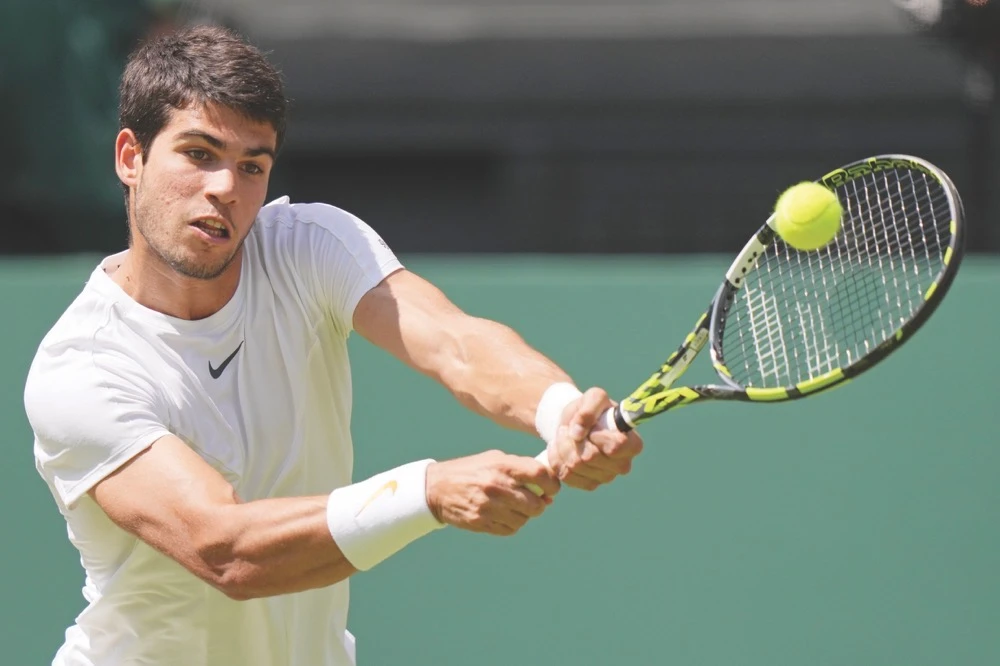Spain’s Carlos Alcaraz returns to Alexandre Muller of France in a men’s singles match on day five of the Wimbledon tennis championships in London Friday. (AP)