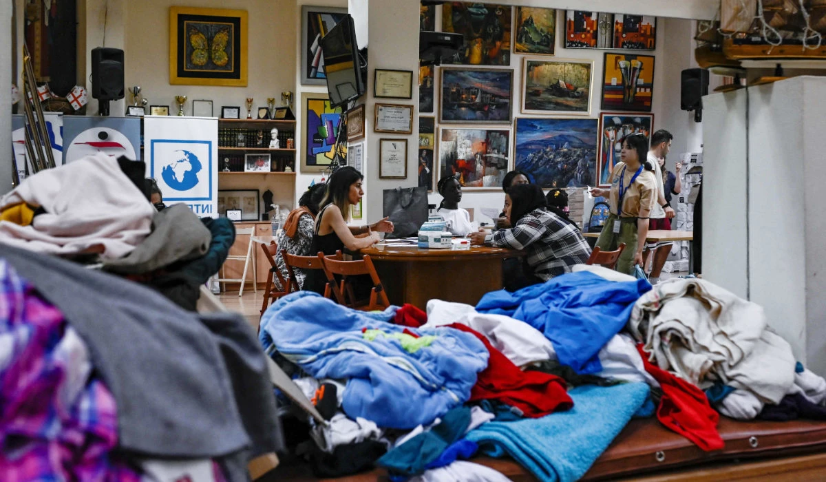 A picture taken on June 26, 2023, shows migrants receiving food and clothes from an NGO in Athens. (AFP)