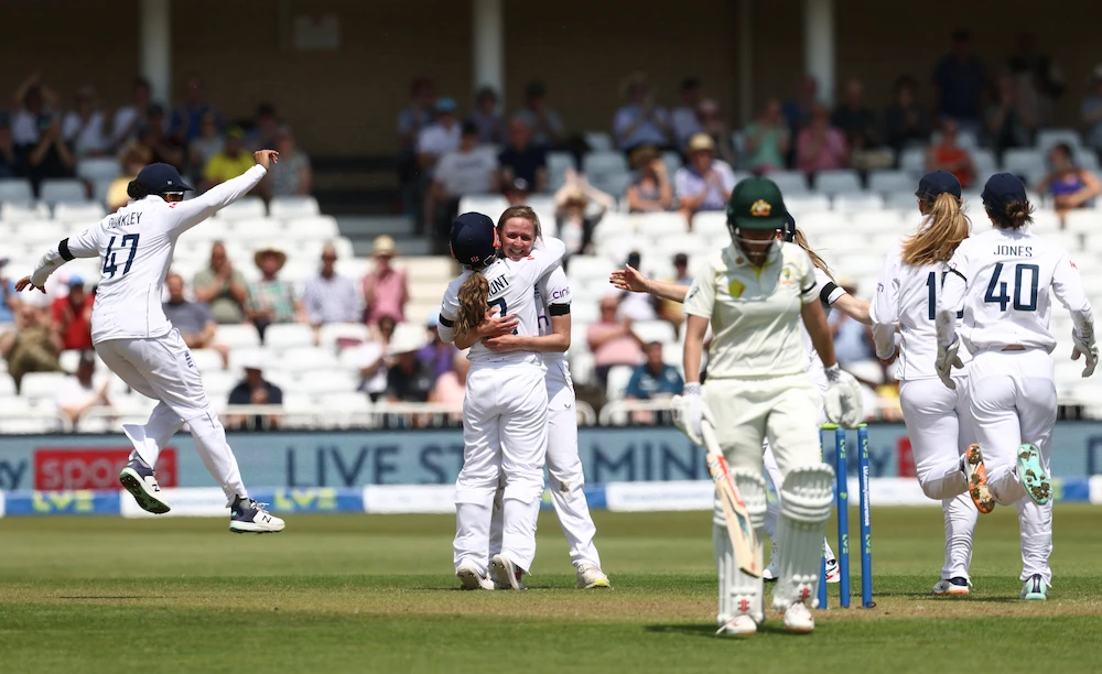 England’s Lauren Filer, center, celebrates with teammates after taking the wicket of Australia’s Beth Mooney during play on day one of the Test match on June 22, 2023. (AFP)
