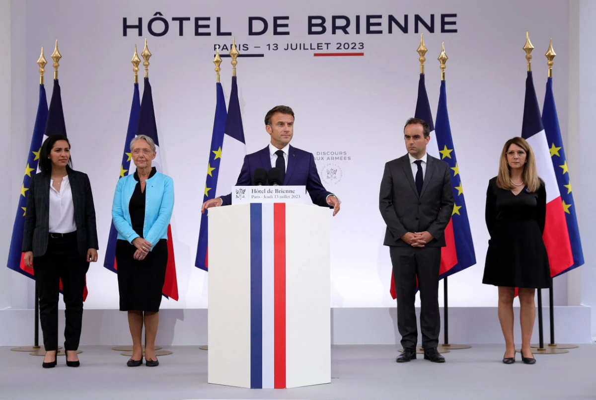 French President Emmanuel Macron, flanked by Defense Minister Sebastien Lecornu and Prime Minister Elisabeth Borne, delivers his speech to military staff on the eve of Bastille Day, at the Defense Minister's residence in Paris on July 13, 2023. (Pool via REUTERS)
