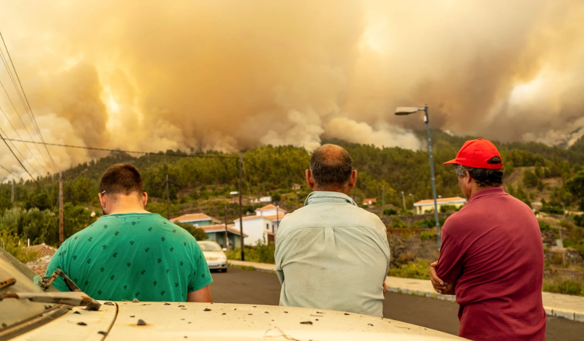Local residents look on at a burning forest fire, near Puntagorda on the Canary Island of La Palma, Saturday, July 15, 2023. (AP)