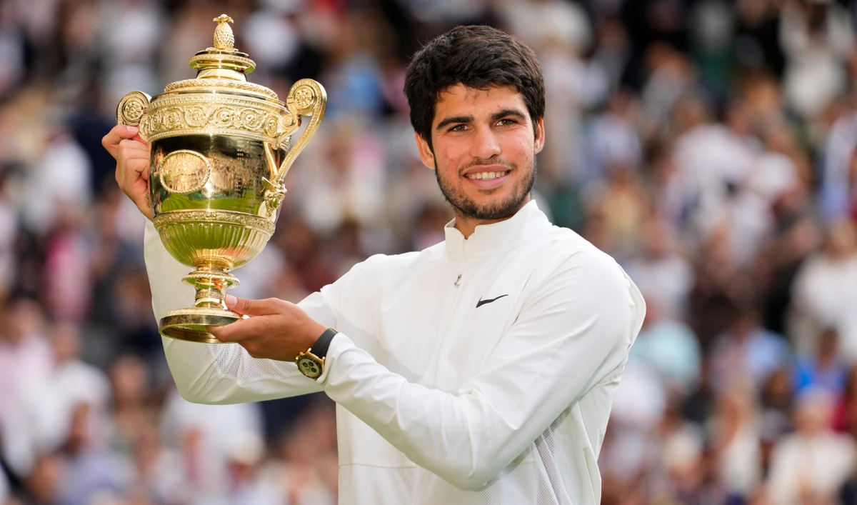 Spain’s Carlos Alcaraz celebrates with the trophy after beating Serbia’s Novak Djokovic to win the final of the men’s singles on day fourteen of the Wimbledon tennis championships in London, Sunday, July 16, 2023. (AP)