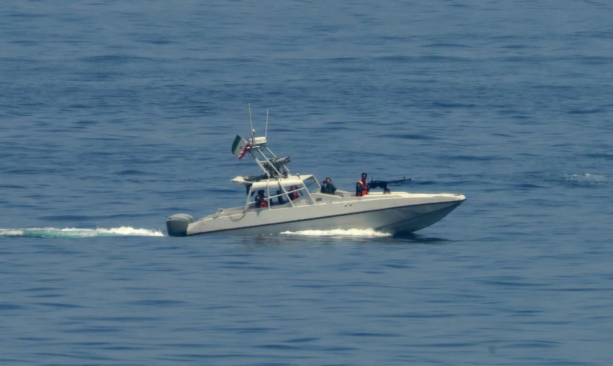 An Iranian Revolutionary Guard speedboat watching an American warship in the Strait of Hormuz. (AP/File)