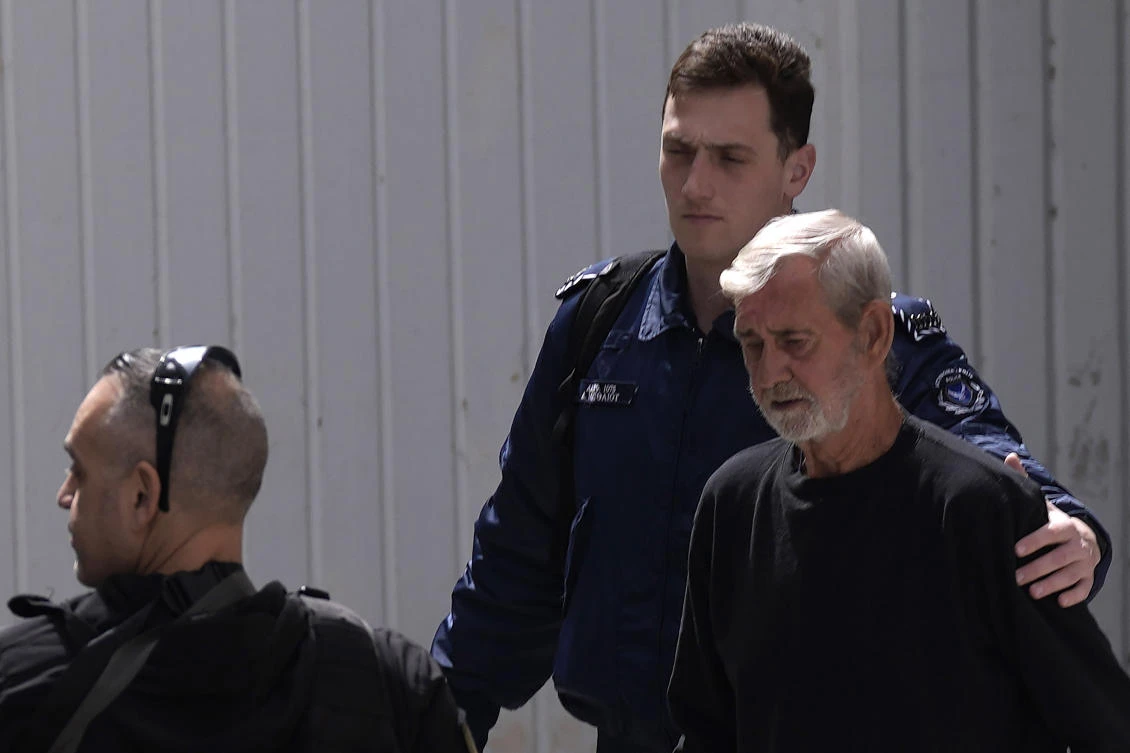 Police officers escort Briton David Hunter as he leaves the grounds of the courthouse complex after a trial on a premeditated murder charge in the death of his ill wife, in Cyprus on Mar. 21, 2023. (AP/File)