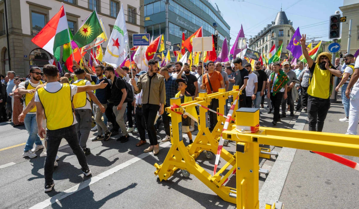 Members of the Kurdish community walk past security fences during a march to mark the 100th anniversary of the Treaty of Lausanne, in Lausanne on July 22, 2023. (AFP)