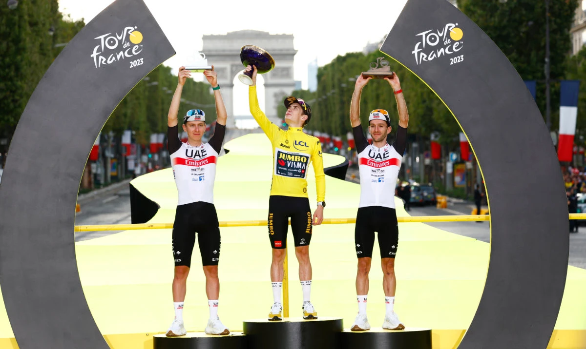 Tour de France winner Denmark's Jonas Vingegaard, center, second-place Slovenia's Tadej Pogacar, left, and third-place Britain's Adam Yates celebrate on the podium after the 21st and final stage of the Tour de France cycling race Sunday. (AP)