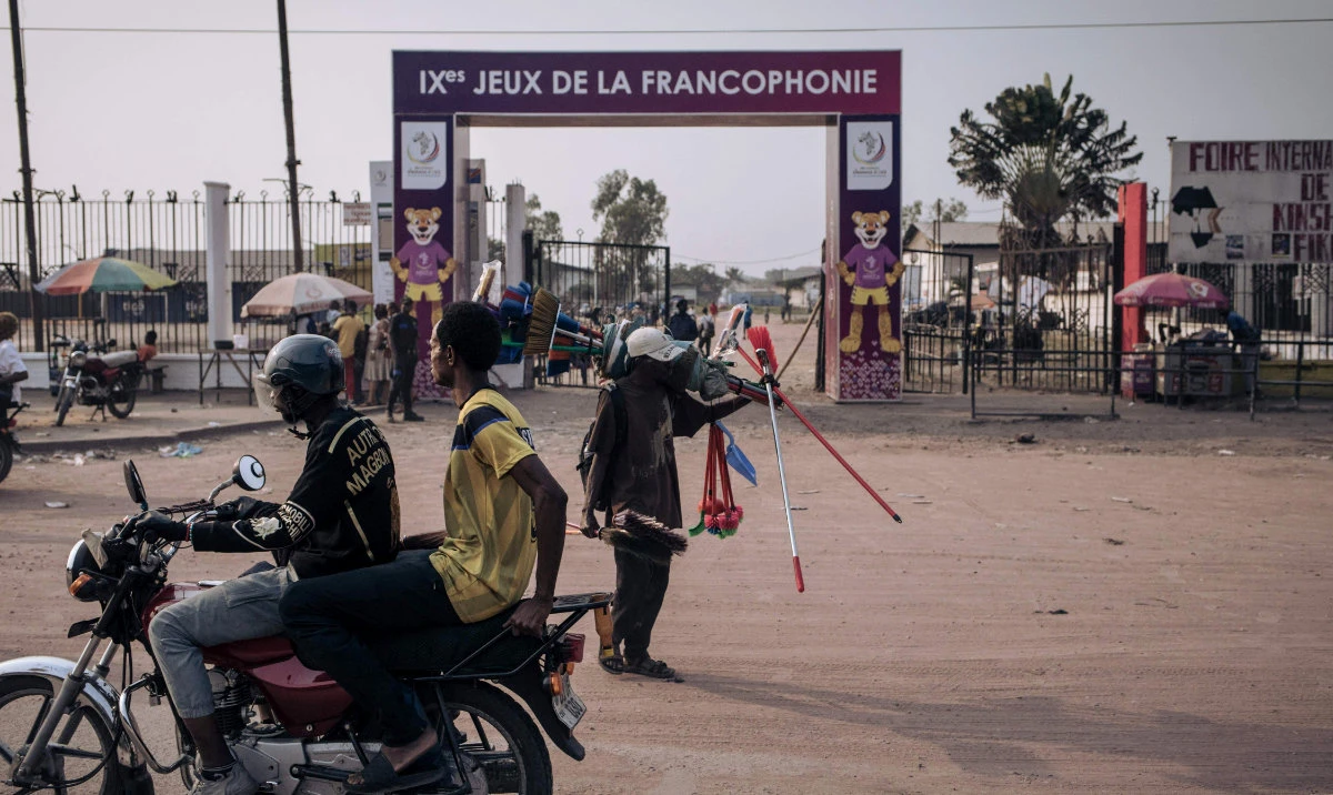 Residents walk past the entrance to one of the facilities of the 9th Jeux de la Francophonie in Kinshasa Tuesday. The 9th Francophone Games, a gathering of some 3,000 young athletes and artists from some 30 countries, opens Friday in Kinshasa. (AFP)