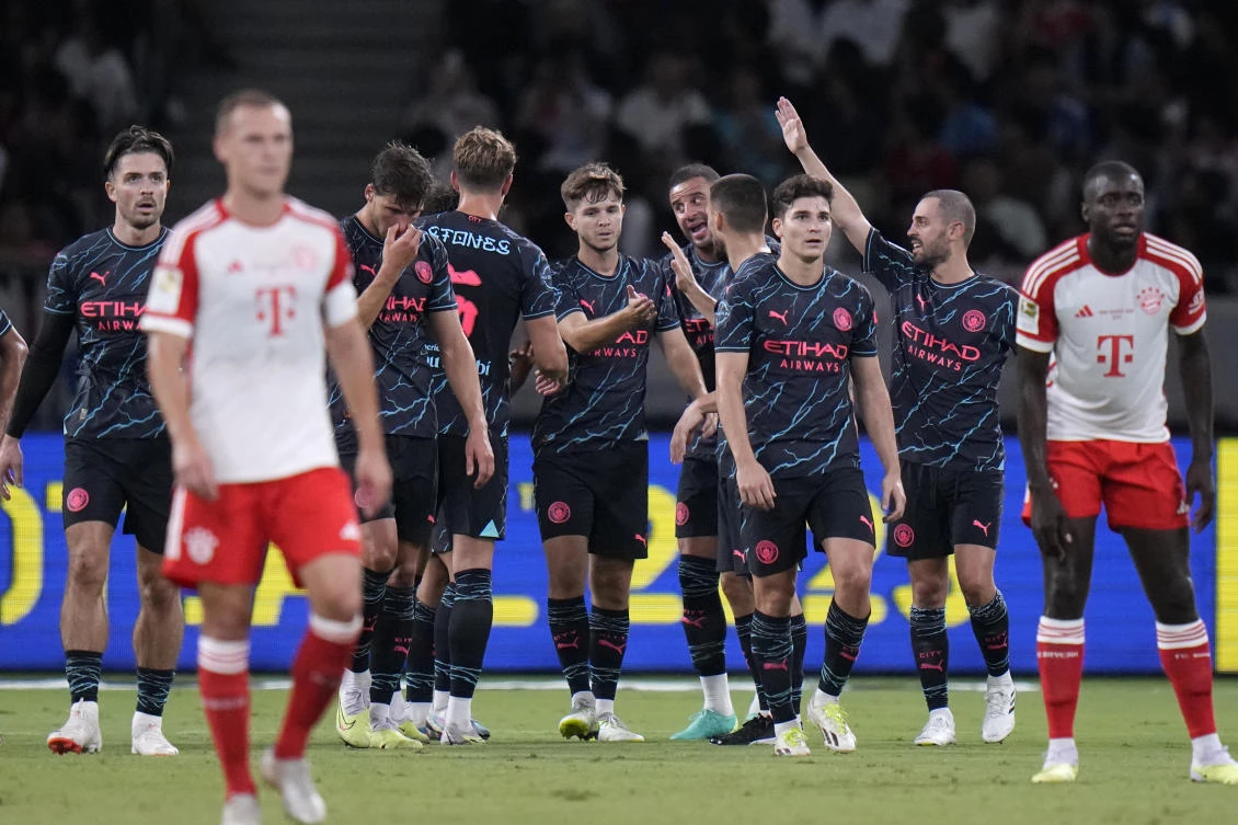 Manchester City’s James McAtee, center, celebrates with teammates after scoring a goal against Bayern during a friendly match at the National Stadium in Tokyo on July 26, 2023.(AP)