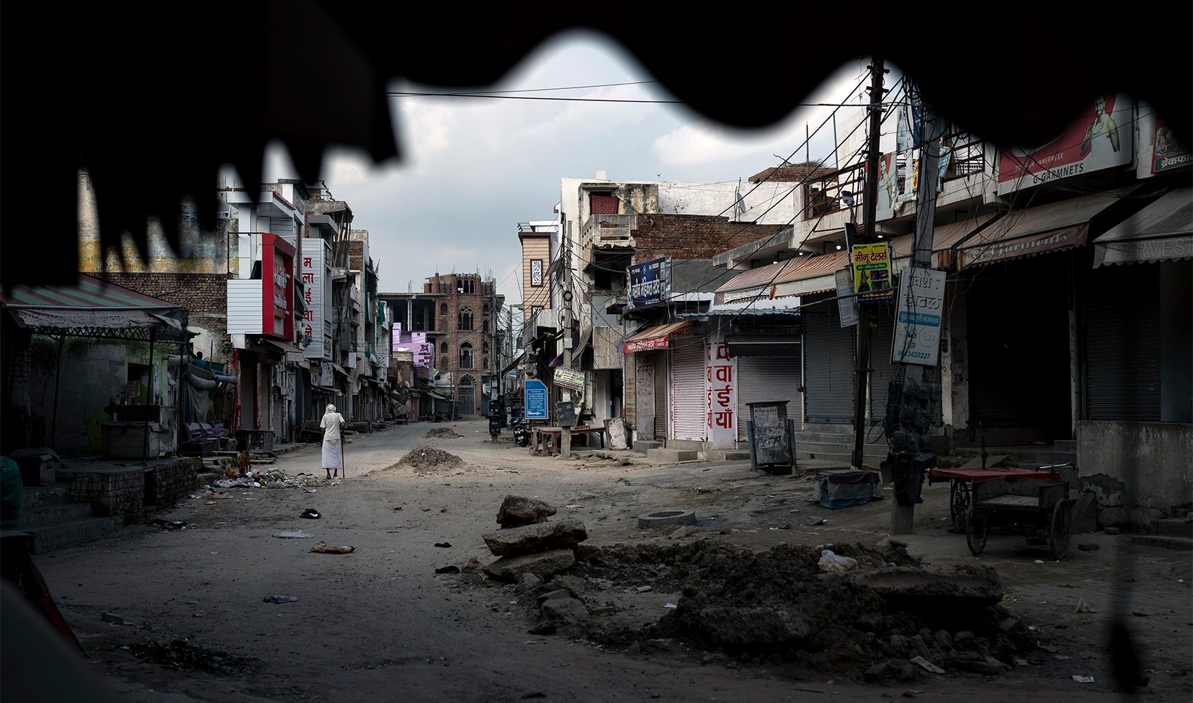 An elderly man walks in an area deserted after communal clashes in Nuh in Haryana state, India, on August 1, 2023. (AP)