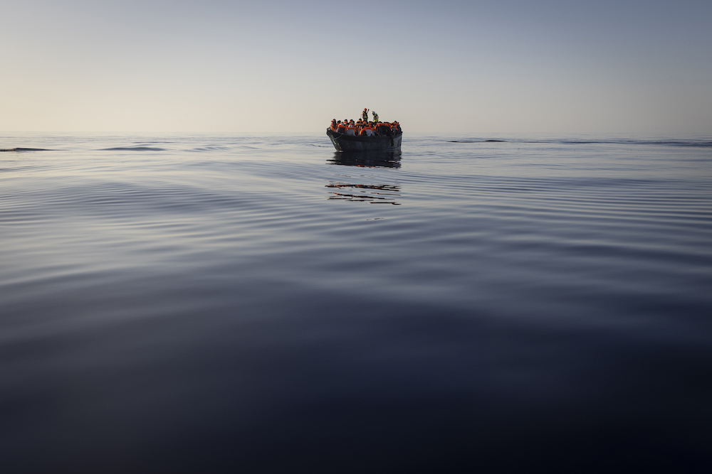 Migrants with life jackets provided by volunteers of a migrant search and rescue group as they are being rescued on Aug. 27, 2022 in the Mediterranean sea. (AP)