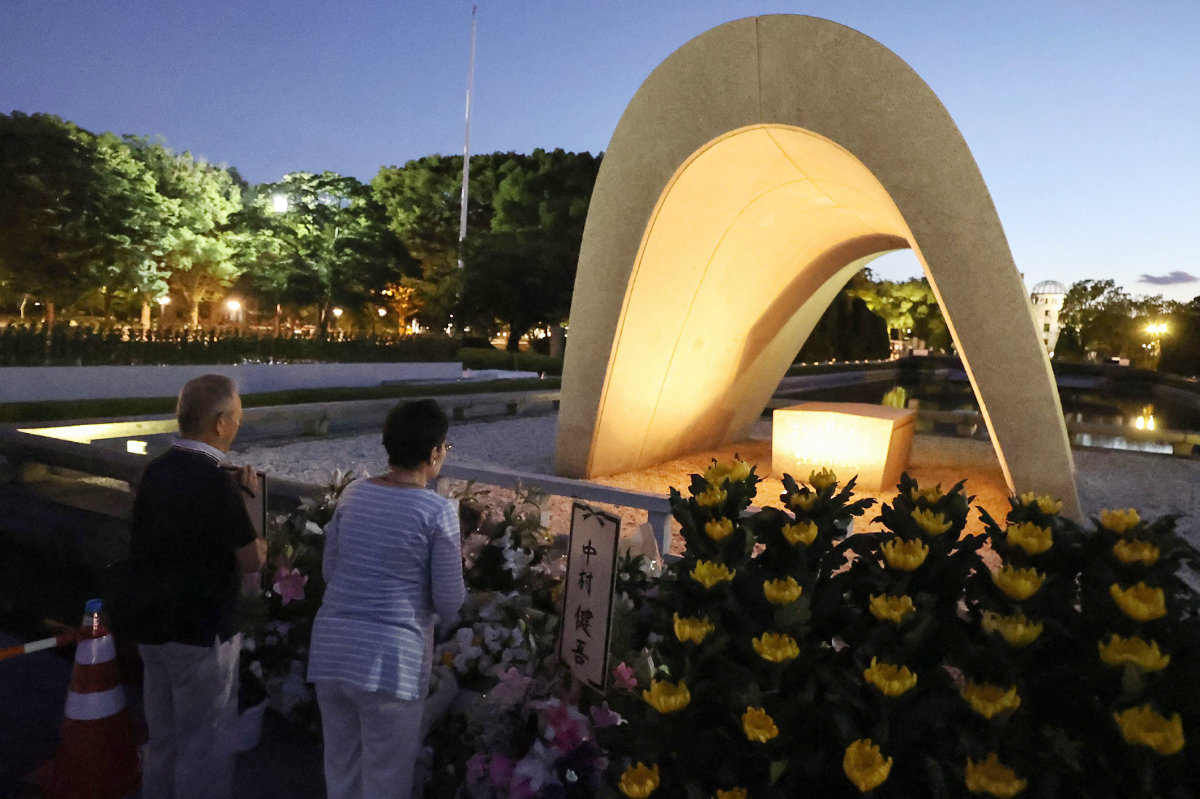 People visit and say prayers at sunrise at the cenotaph for the atomic bomb victims at the Peace Memorial Park in Hiroshima on August 6, 2023, to mark the 78th anniversary of the world's first atomic bomb attack. (AFP)