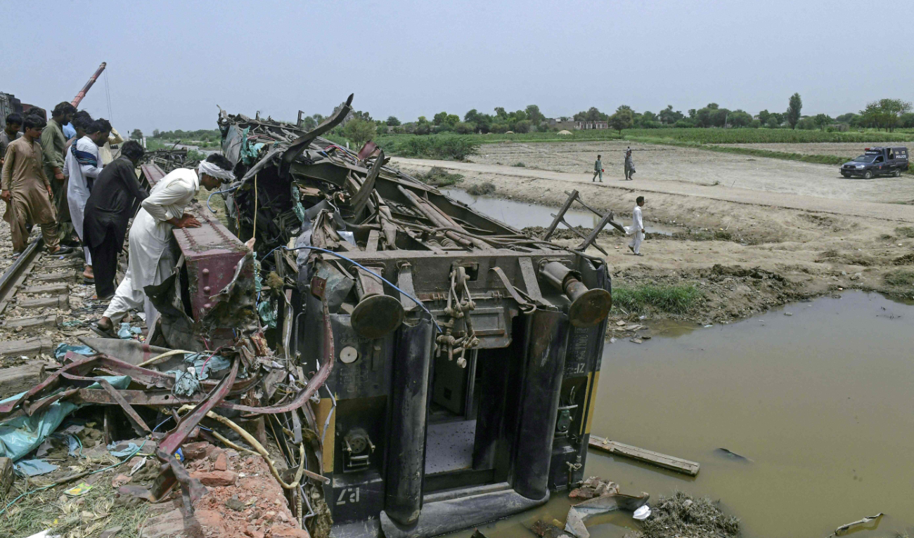 People gather at the accident site, a day after the derailment of a passenger train in Nawabshah on August 7, 2023. (AFP)