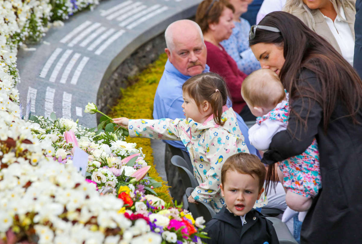 Floral tributes are laid in the garden as family members of those killed in the Omagh bomb attack gather in the memorial garden for a service on the 25th anniversary of the Omagh bombing, in tribute of the victims, in the city centre of Omagh, on August 13, 2023. (AFP)