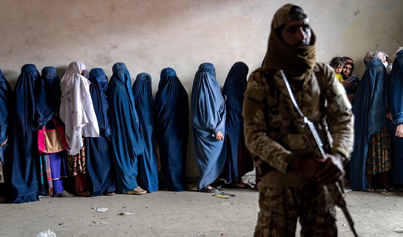 A Taliban fighter stands guard as women wait to receive food rations distributed by a humanitarian aid group in Kabul, Afghanistan, Tuesday, May 23, 2023. (AP/File)