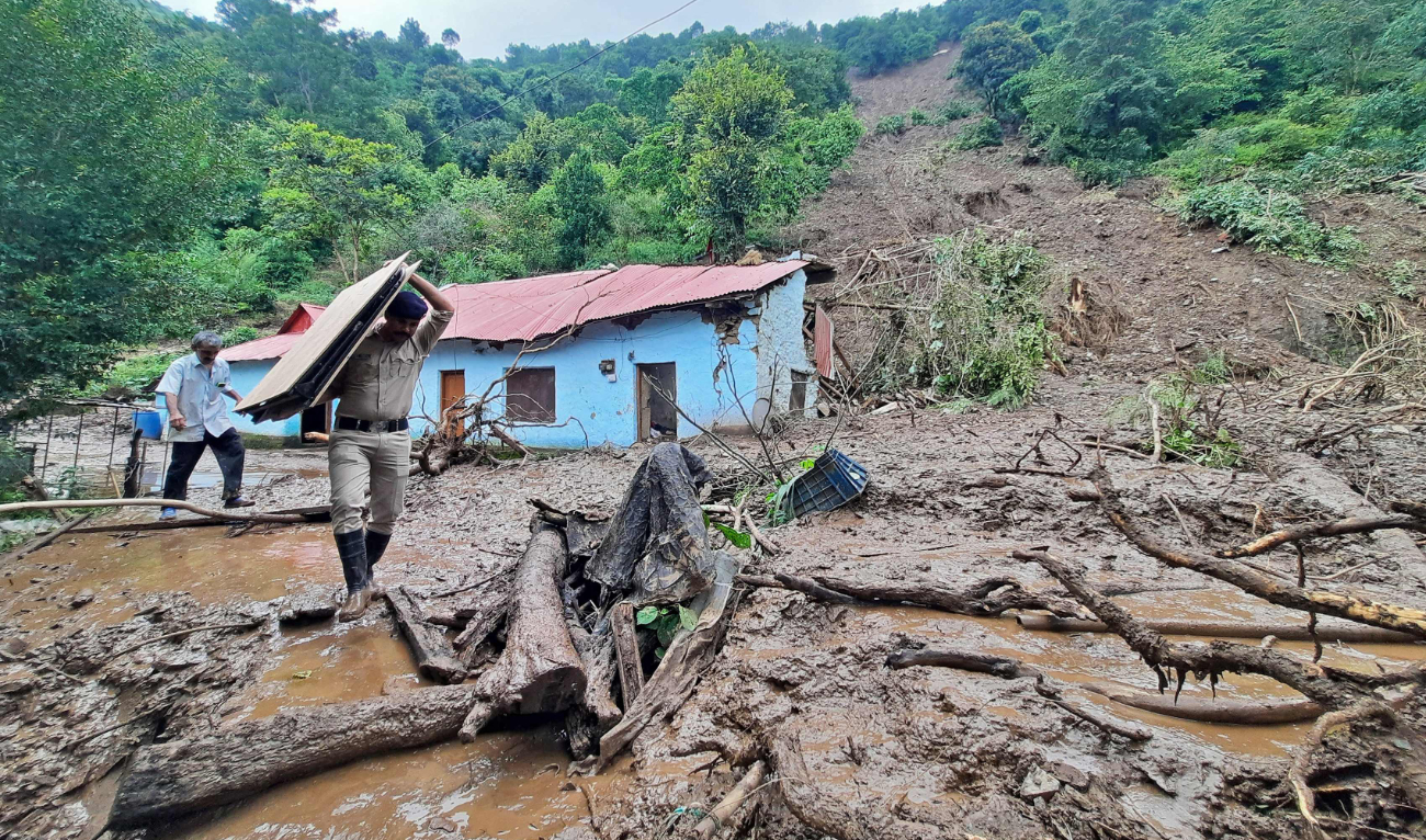 A rescuer carries the belongings of a villager from the site of a landslide at Jadon village in India’s Himachal Pradesh state on Monday. (AFP)
