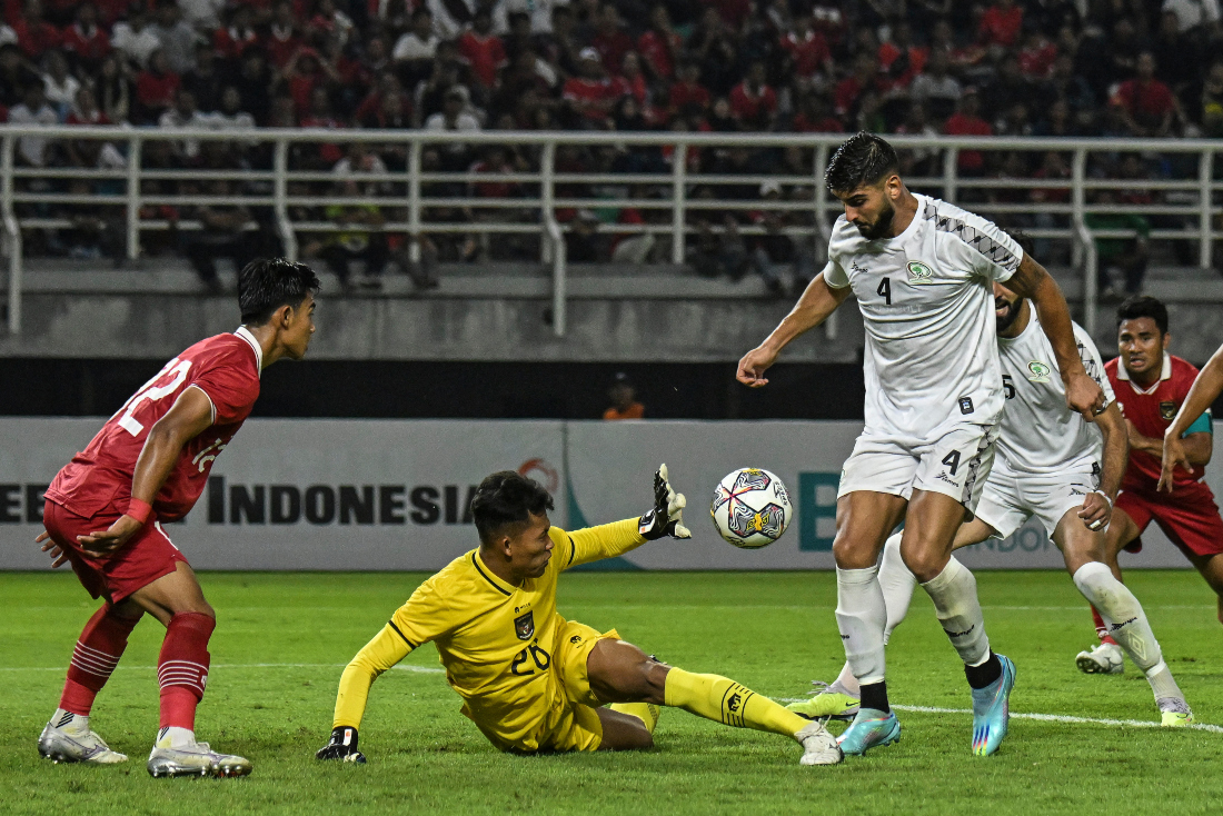 Indonesia's goalkeeper Syahrul Trisna tries to make a safe next to Palestine's Yaser Hamed Mayor (R) during the international friendly football match between Indonesia and Palestine. (File/AFP)