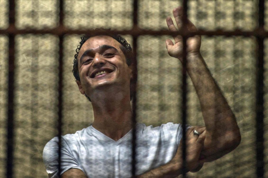 Egyptian political activist Ahmed Douma reacts as he stands behind dock bars during his trial in Cairo on June 3, 2013. (AFP)