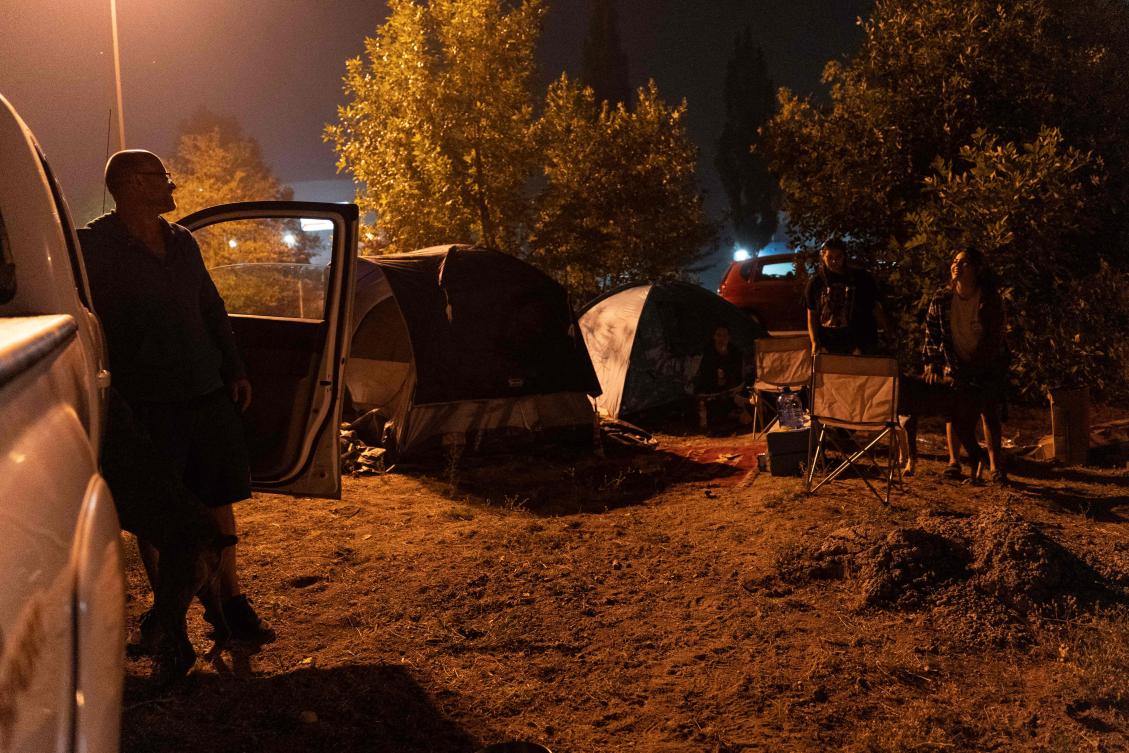 Family members Eren Loney, Shannon Fiddler, Paryss Fiddler and Shay Nicole and their pets rest at the Jim Lind Arena after registering with Emergency Support Services after being ordered to evacuate amid raging wildfires. (AFP)