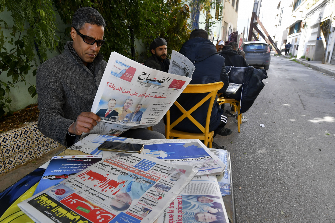 Tunisian man reads the latest news on newspapers in Tunis, following a crackdown that has targeted activists, former lawyers and prominent businessman. (File/AFP)