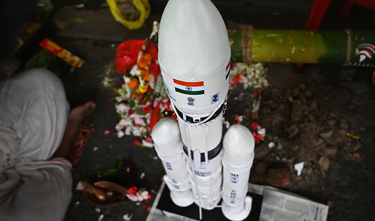 A Hindu priest performs a special prayer for the success of the Chandrayaan-3 mission next to a model of the spacecraft LVM3-M4 used to launch it, during a religious function in Kolkata on August 20, 2023. (AFP)