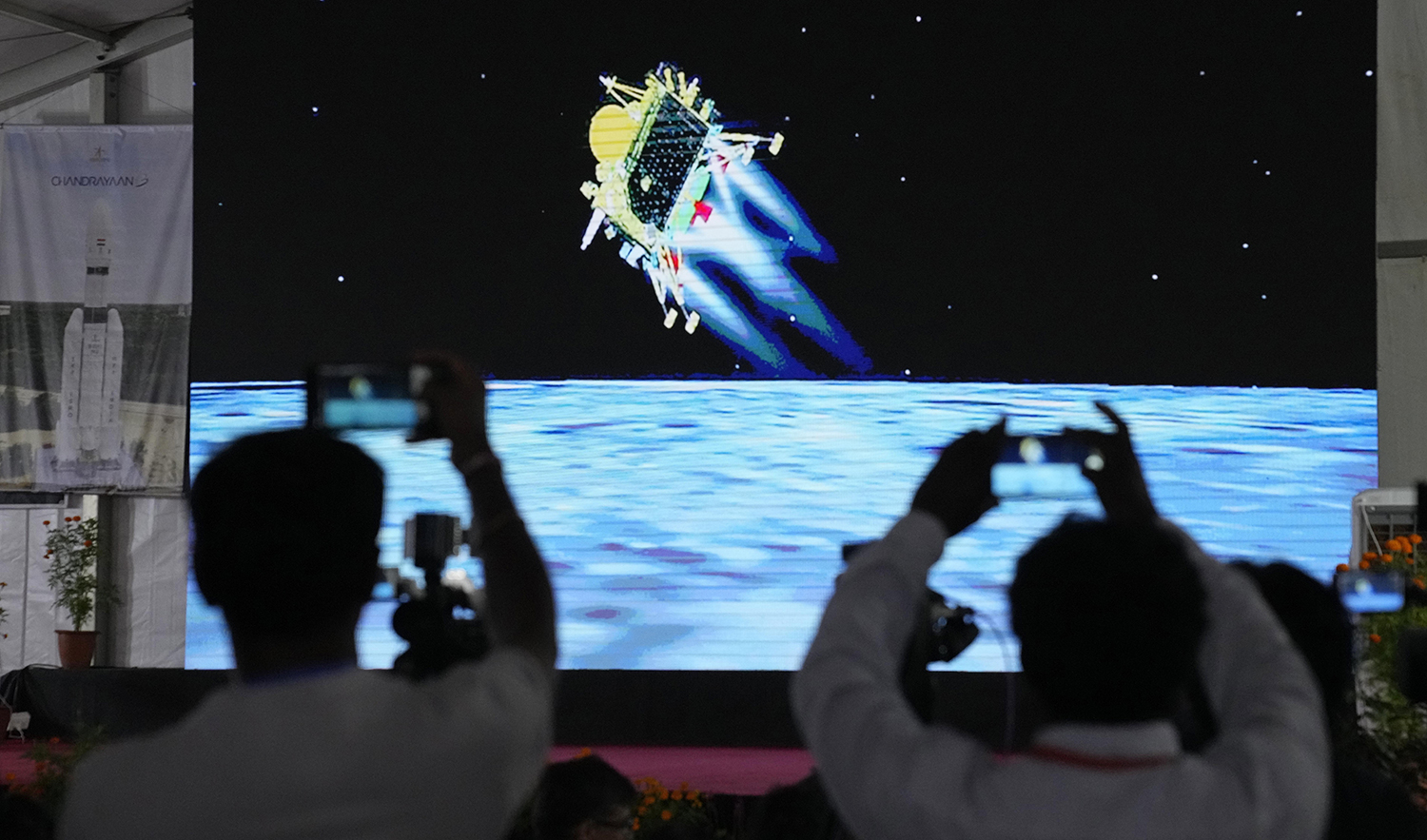 Journalists film the live telecast of spacecraft Chandrayaan-3 landing on the moon at ISRO's Telemetry, Tracking and Command Network facility in Bengaluru, India, on August 23, 2023. (AP)