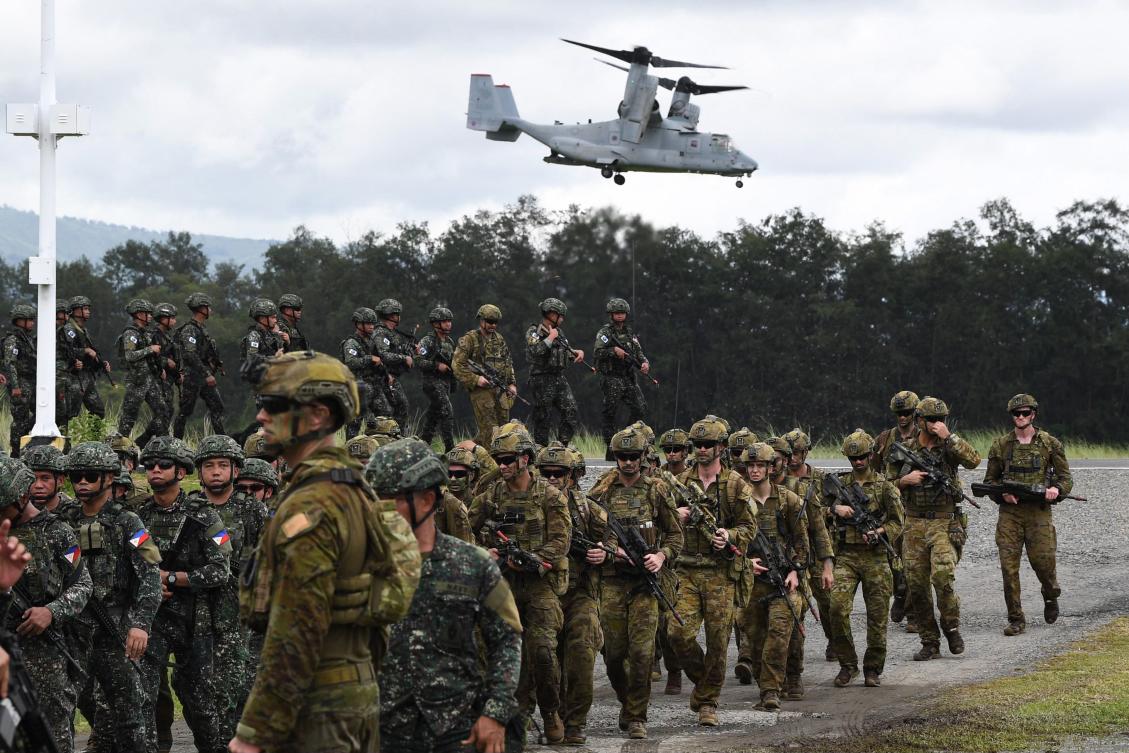 Philippine and Australian soldiers march in formation while a US marines V-22 Osprey hovers above during the military exercise Alon (Wave) at a naval base in San Antonio town in Zambales province. (AFP)