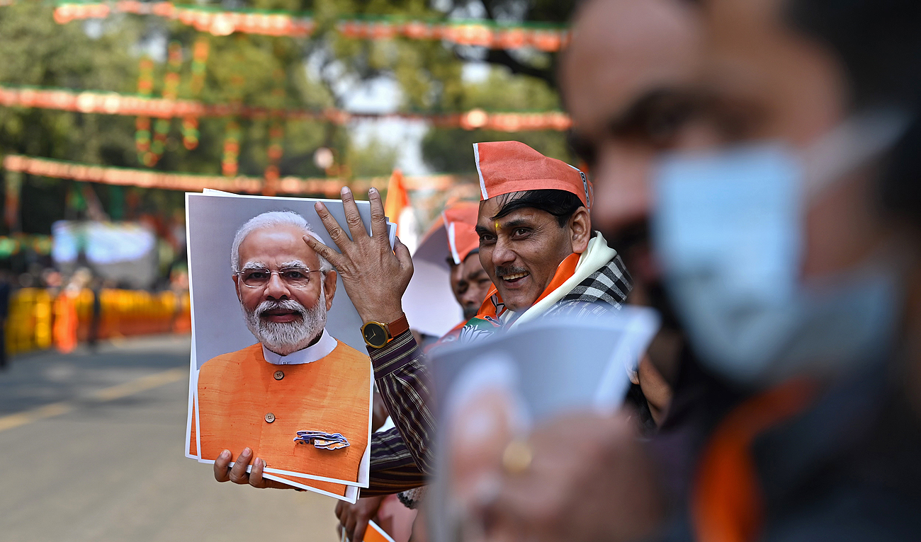 A supporter of the Bharatiya Janata Party (BJP) holds a picture of India's Prime Minister Narendra Modi during a roadshow ahead of the BJP national executive meet in New Delhi on January 16, 2023. (AFP/File)