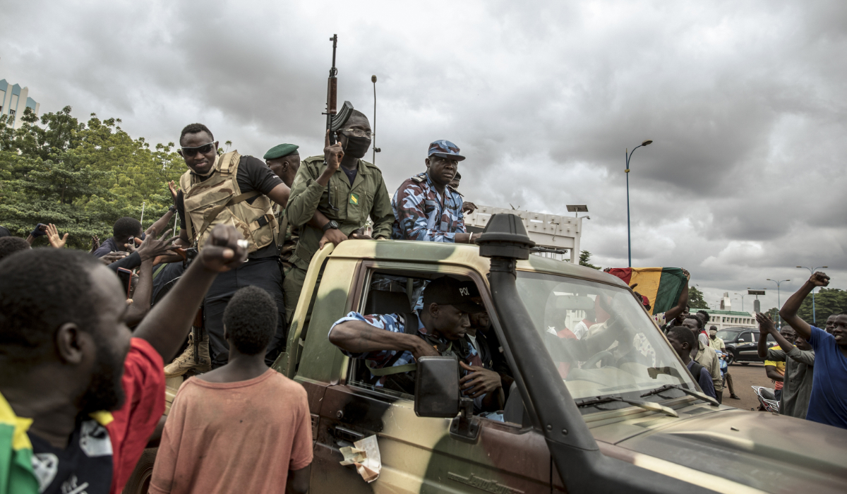 People cheer in celebration as security forces drive through the streets of the capital Bamako, Mali, Wednesday, Aug. 19, 2020, a day after armed soldiers fired into the air outside President Ibrahim Boubacar Keita's home and took him into their custody. (AP)