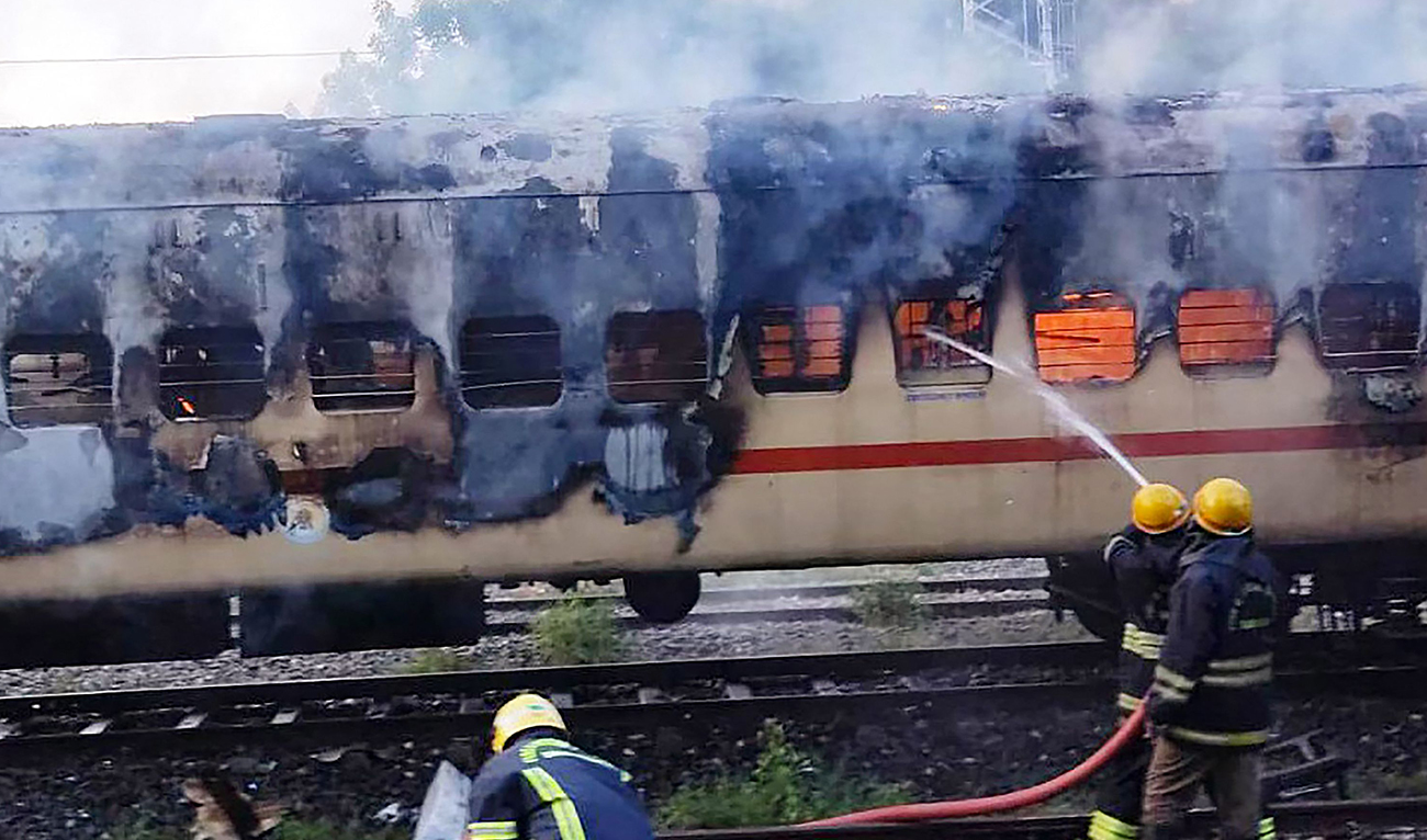 Firefighters try to extinguish a fire which broke out in a train coach parked at the Madurai railway yard, in Madurai on August 26, 2023. (Photo courtesy: AFP)