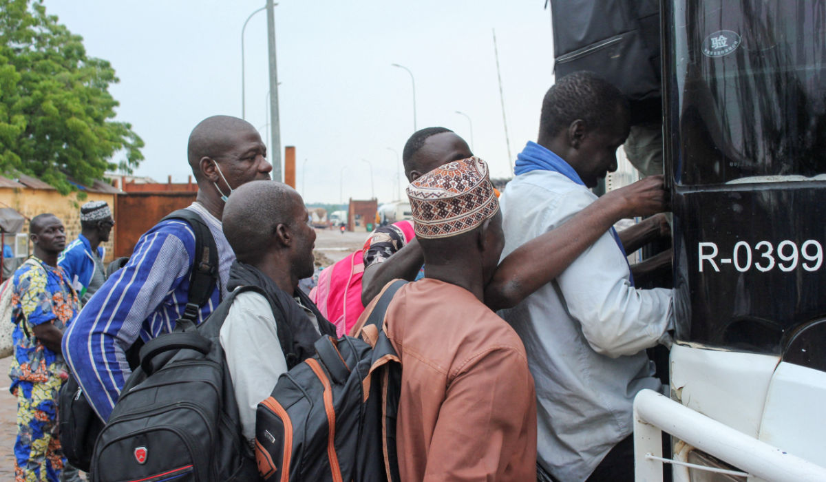 Nigerien nationals board a bus in the border town of Malanville, Benin, to travel to neighboring countries. The junta is resisting regional pressure to stand down. (Reuters)