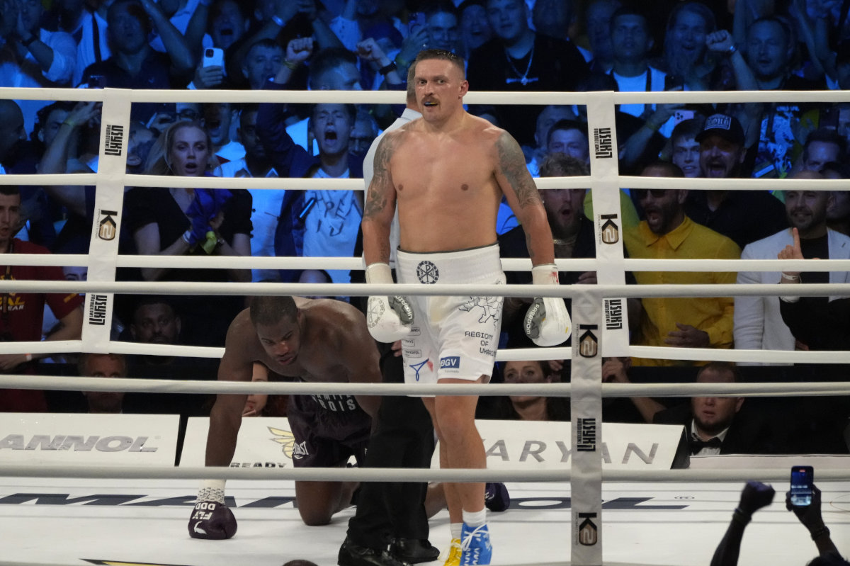 Ukraine's Oleksandr Usyk waits as Britain's Daniel Dubois takes a knee during their world heavyweight title fight at Tarczynski Arena in Wroclaw, Poland, on Sunday. (AP)