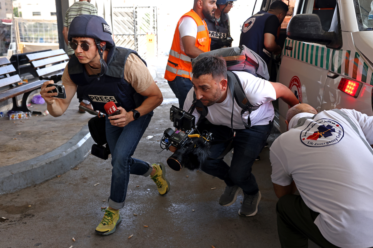Journalists rush for cover inside a hospital in Jenin in the occupied West Bank. (File/AFP)