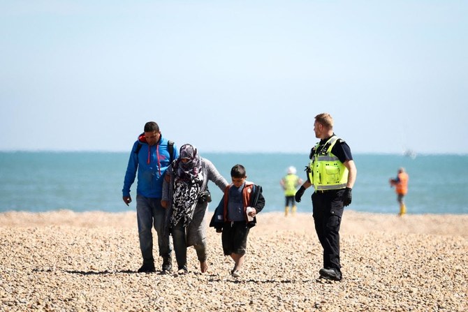 A migrant pregnant woman is helped by a man and a child after disembarking from a RNLI lifeboat. (File/AFP)