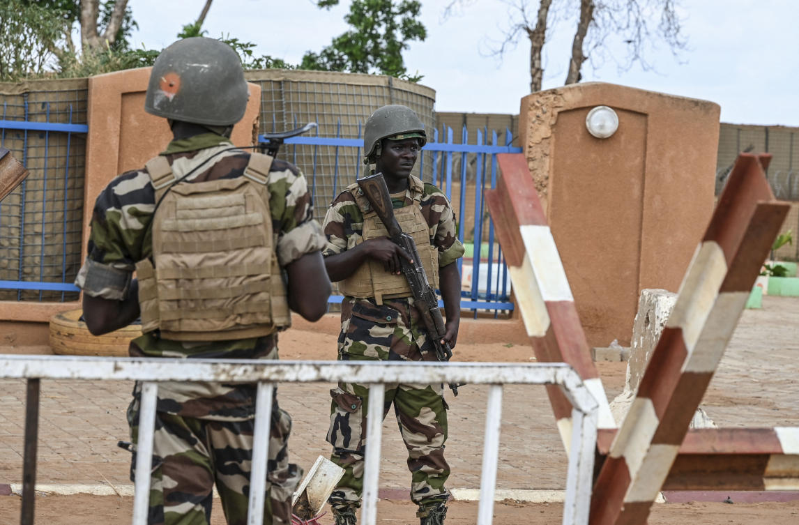 Nigerien police soldiers stand guard outside the Niger and French air bases in Niamey as supporters of Niger’s National Council for the Safeguard of the Homeland (CNSP) gather on August 27, 2023. (AFP)