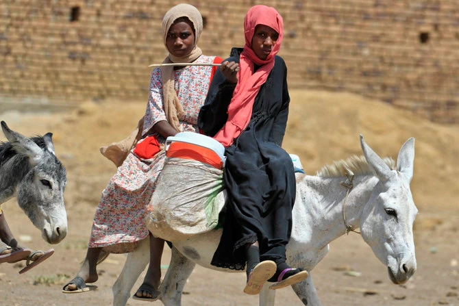 Sudanese women ride their donkeys as they move away from violence in Sudan's capital Khartoum. (AFP/File)