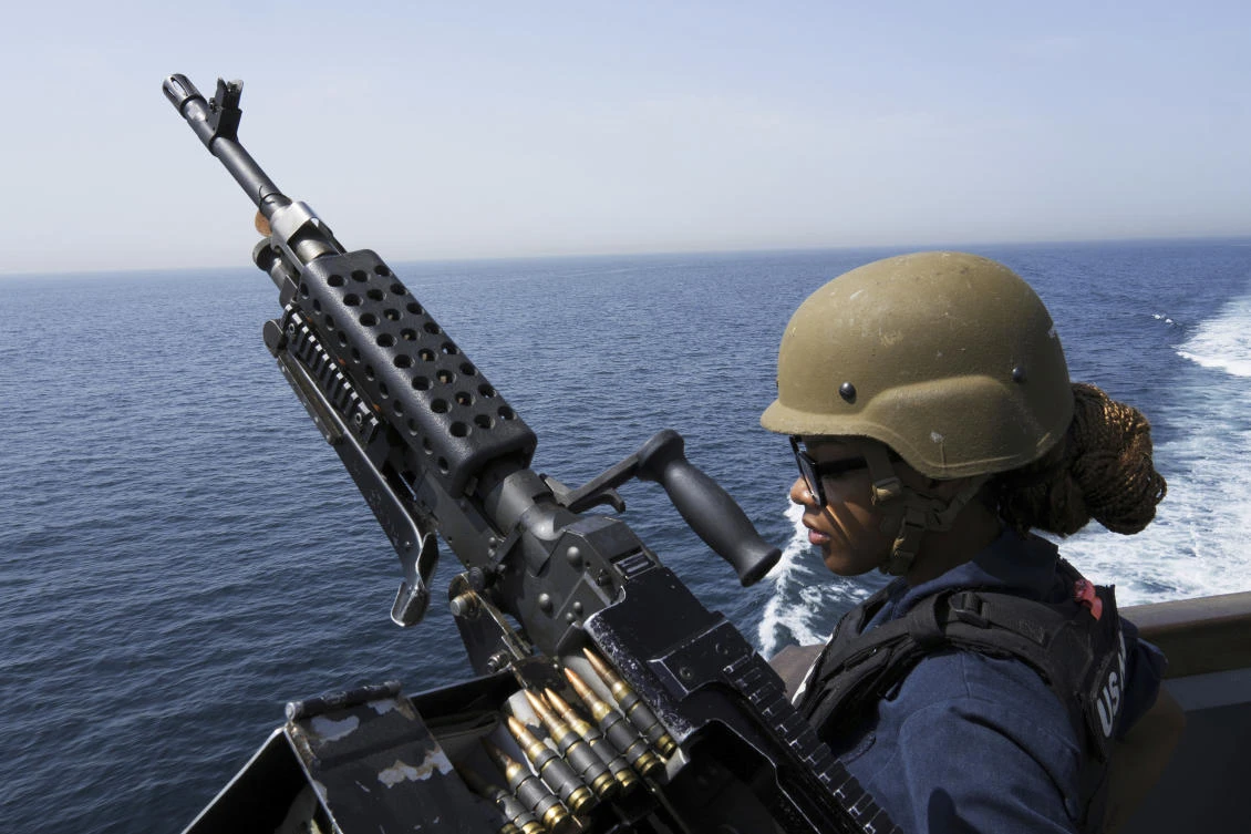 US Navy retail service specialist Artayja Stewart of Clarksville, Tenn., stands guard next to a machine gun aboard the USS Paul Hamilton in the Strait of Hormuz. (File/AP)