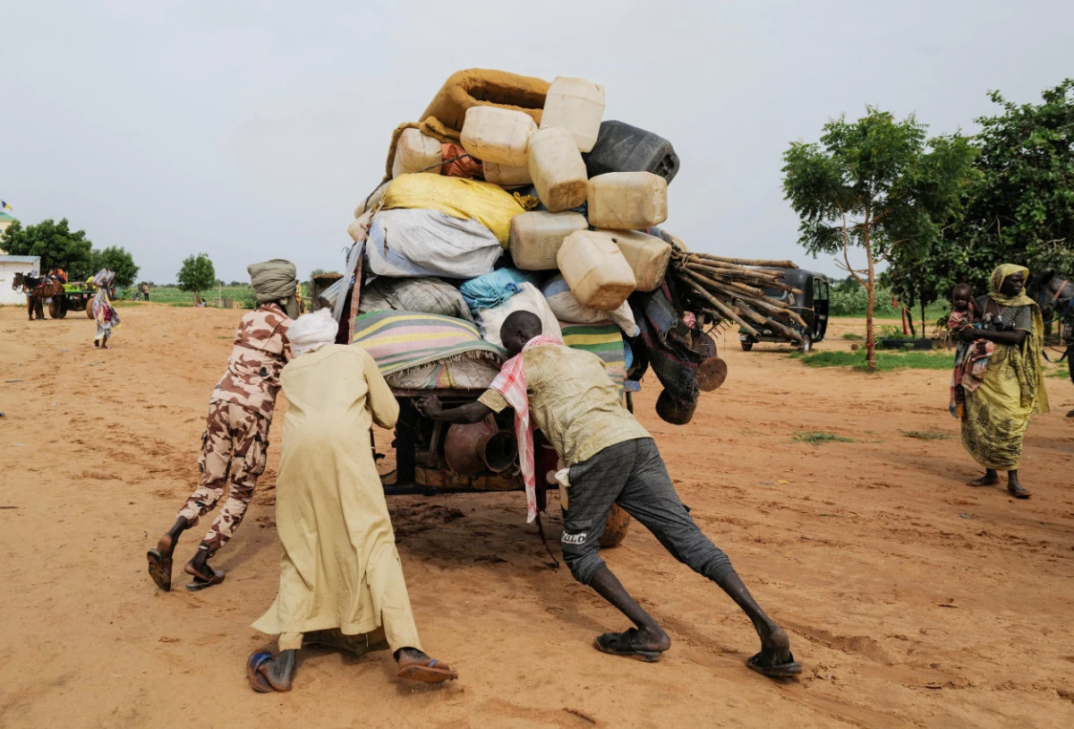 A Chadian cart owner who transports belongings of Sudanese people who fled the conflict in Sudan's Darfur region, pushes his cart while crossing the border between Sudan and Chad in Adre, Chad August 4, 2023. (REUTERS)