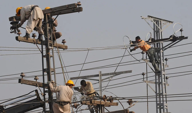 Pakistani technicians work on high voltage power lines in Lahore on Jan. 13, 2011. (AFP/File)