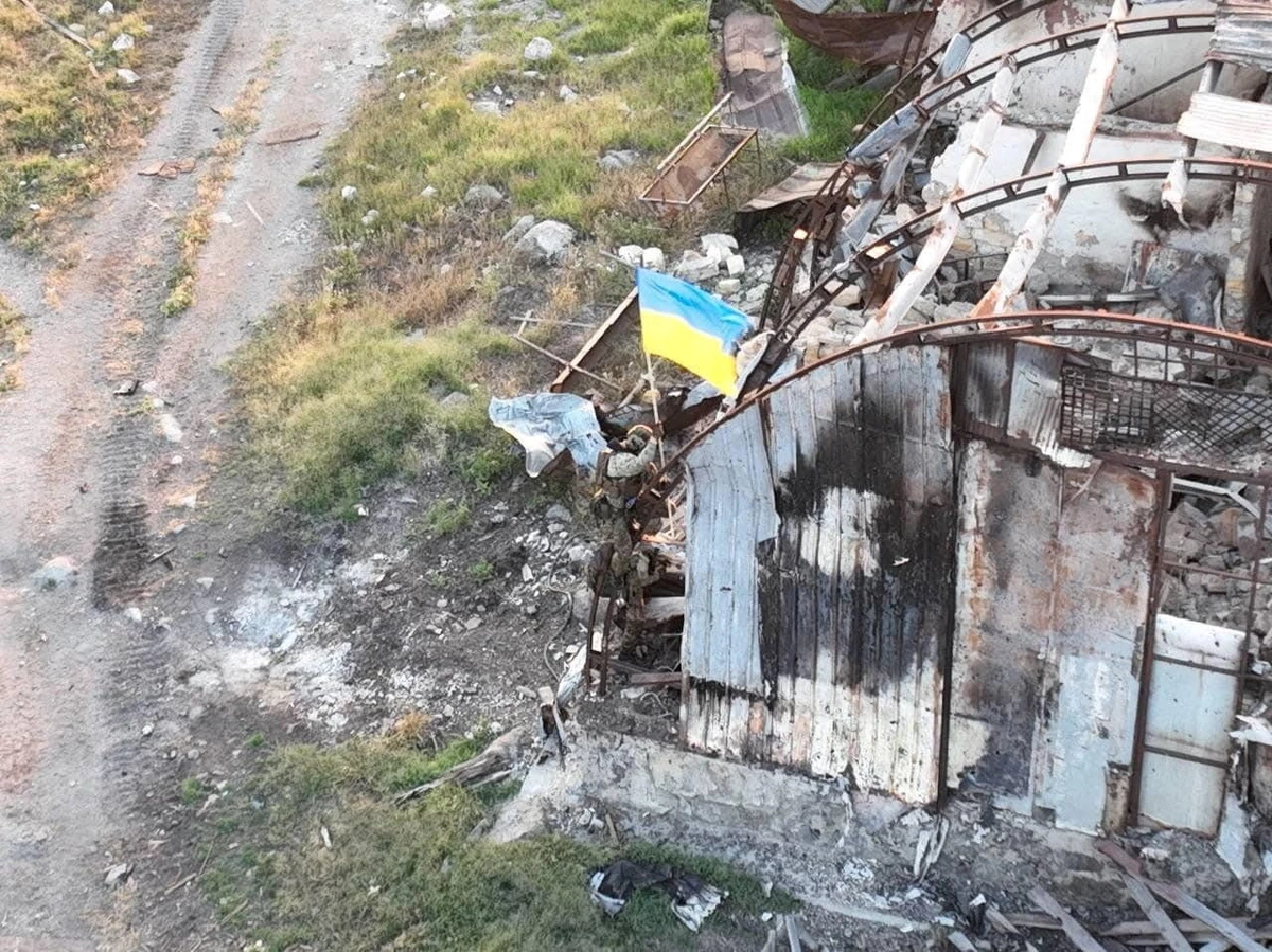 In this photo released on July 7, 2022, Ukrainian service members are seen installing a national flag on Snake (Zmiinyi) Island in Odesa region amid Russia's invasion. (Ukrainian Armed Forces/Handout via REUTERS)