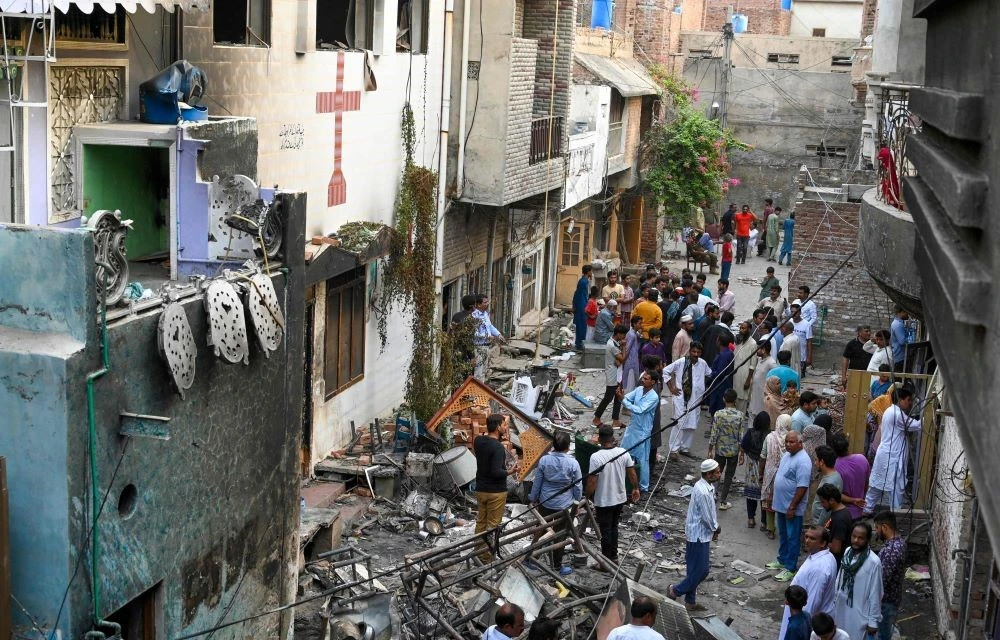 Police and local residents stand amid debris beside Saint John’s church in Jaranwala, outskirts of Faisalabad, Pakistan, Aug. 17, 2023. (AFP)