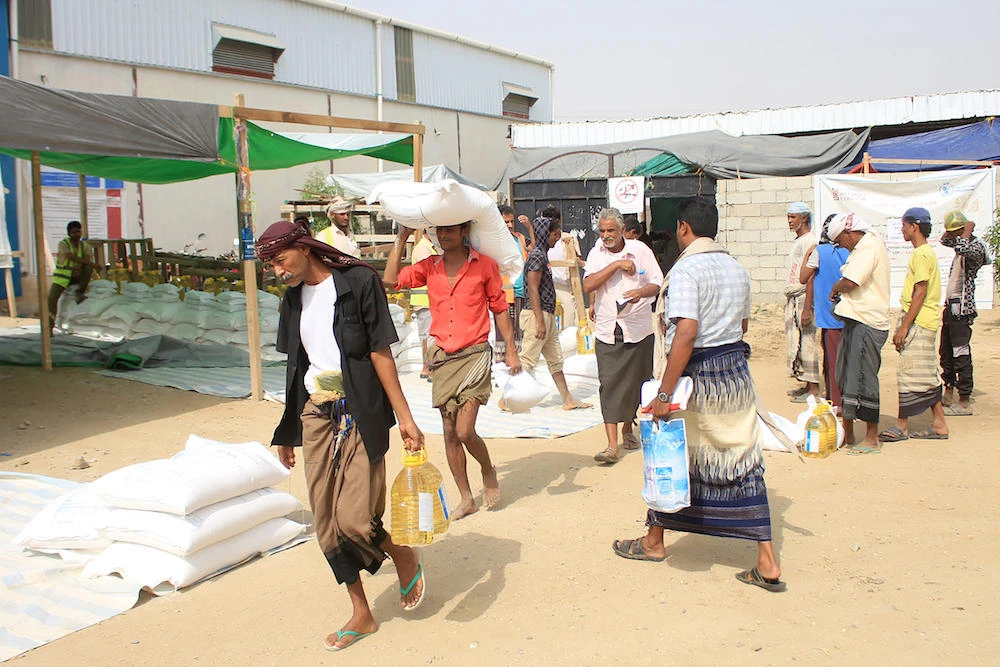 The World Food Programme was forced to slash food aid for 13 million Yemenis by more than 50 percent in June last year because of a funding squeeze. Above, displaced Yemenis in the northern province of Hajjah receive humanitarian aid. (AFP)