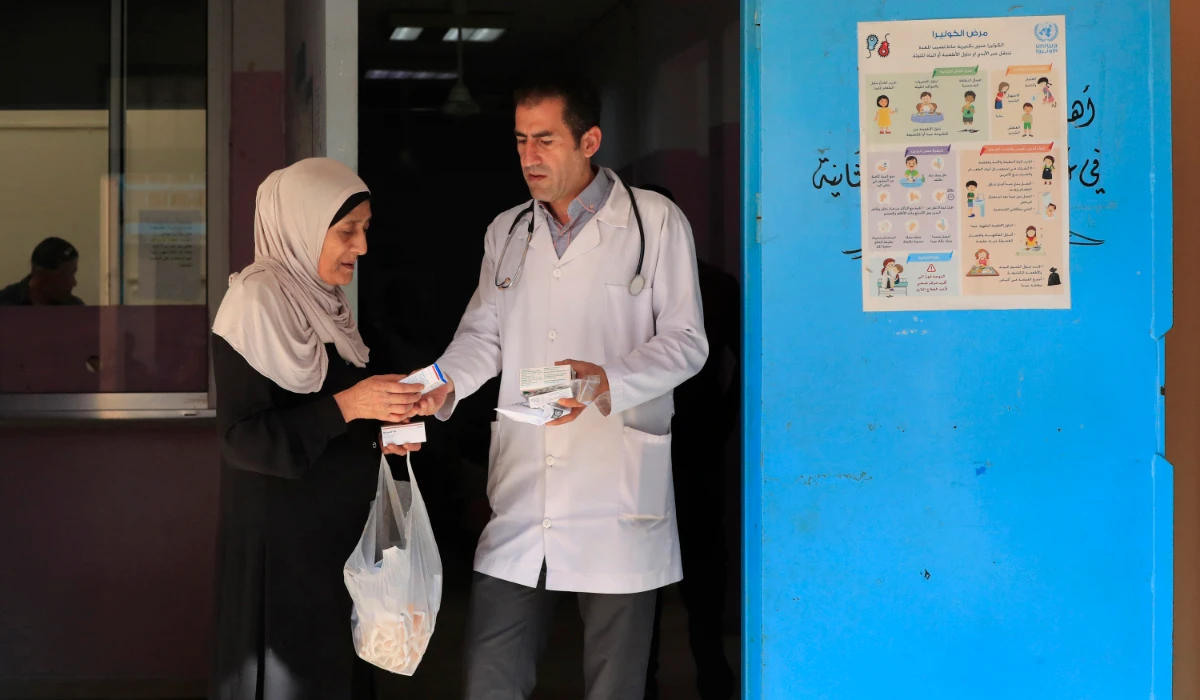 A Palestinian woman received medicine from a doctor at a clinic run by the agency for Palestinian refugees, or UNRWA, in the Ein el-Hilweh refugee camp in the southern port city of Sidon, Lebanon, Tuesday, June 20, 2023. (AP)