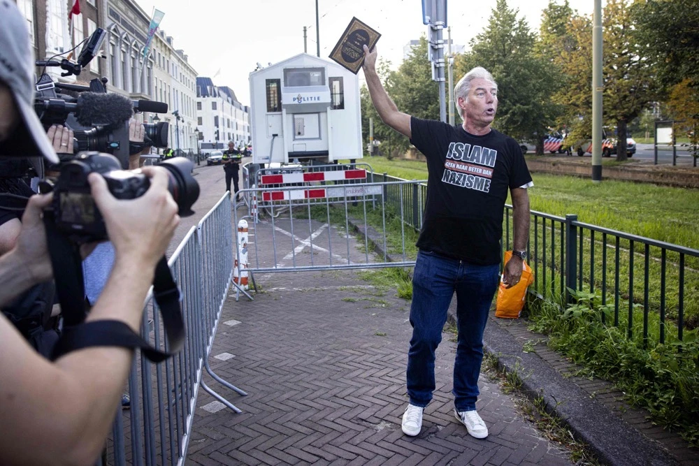 Dutch Edwin Wagensveld, head of the Netherlands' chapter of the far-right anti-Islam movement Pegida (Patriotic Europeans Against the Islamisation of the West) holds up a Qur’an before tearing it up. (ANP / AFP)