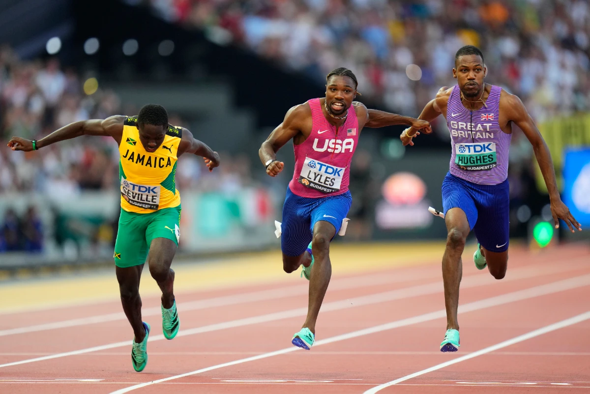 Noah Lyles crosses the line to win the gold medal in the men's 100-meters final ahead of Britain's Zharnel Hughes, bronze, and Jamaica's Oblique Seville during the World Athletics Championships in Budapest on August 20, 2023. (AP)