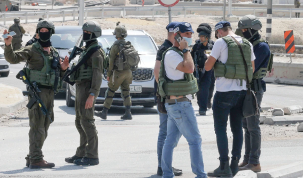 Israeli security forces block a road leading to the site of a reported attack south of Hebron in the occupied West Bank on Monday. (AFP)